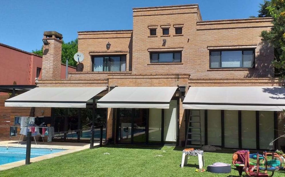 Toldo brazo invisible instalado sobre la galería de una casa